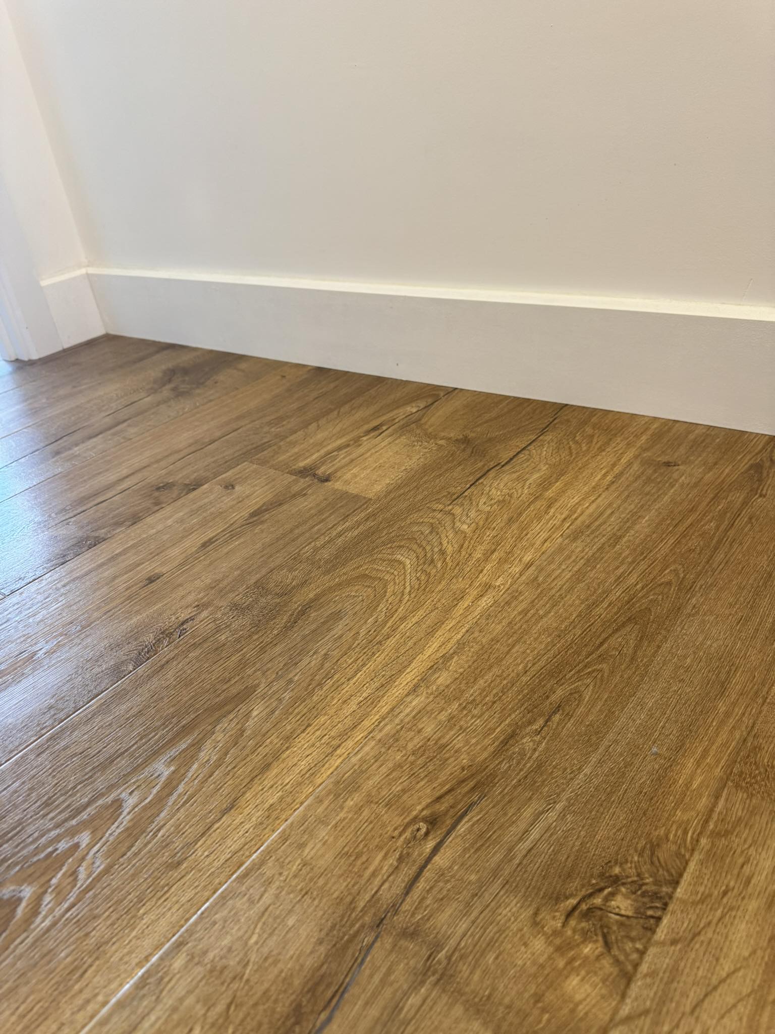 Close-up of timber flooring and white skirting
